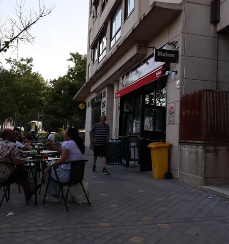 Terraza con mesas y sillas en la puerta del bar, en la calle