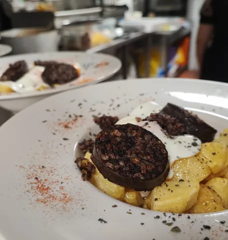 Dos platos de morcilla con huevo y patatas