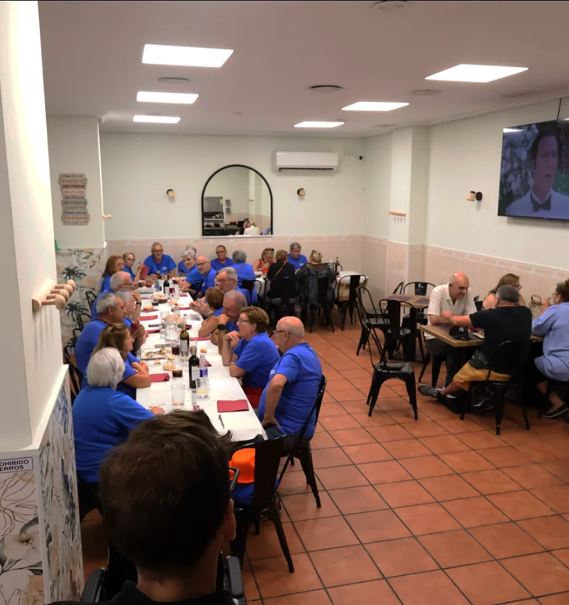 Grupo de personas comiendo en una mesa larga del salón